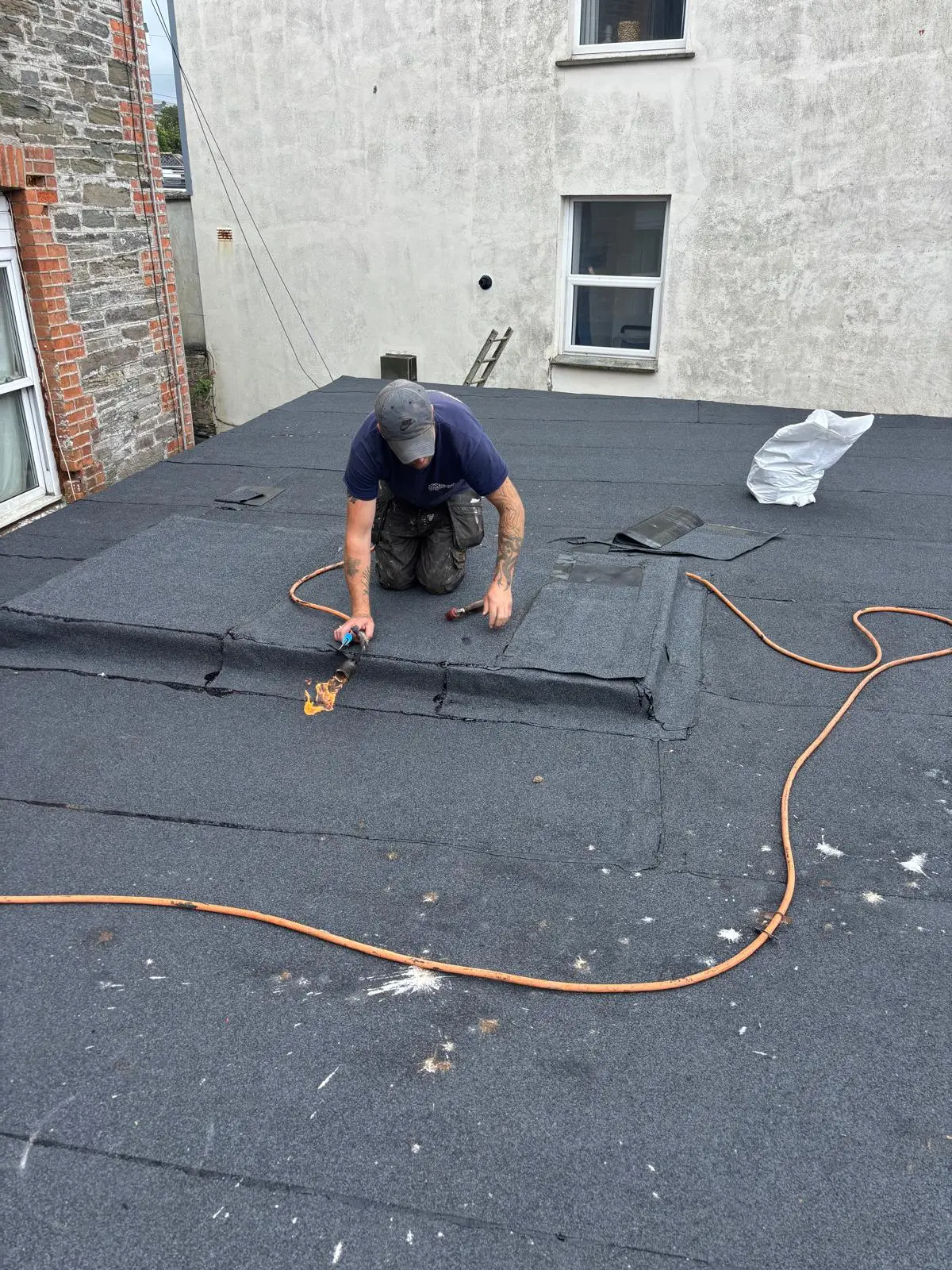 New felt roof being installed during skylight removal