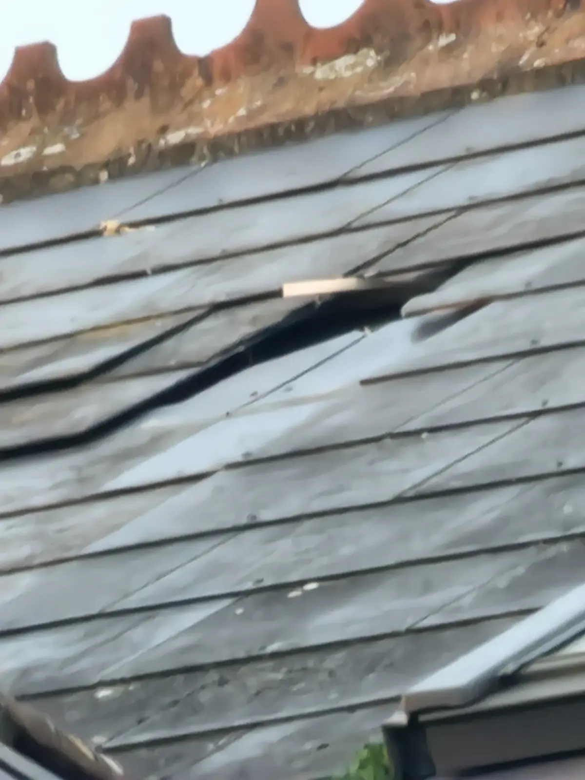 Roof tiles displaced near a chimney